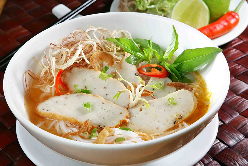 a table of diverse Mui Ne breakfast dishes (bun bo, pho, banh xeo, banh khot)